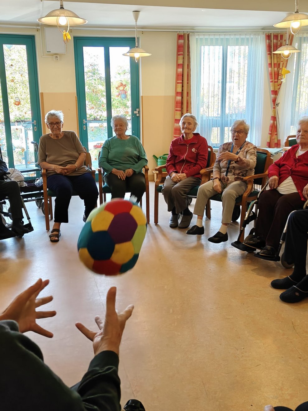 Stoffball fliegt. Hände versuchen Stoffball zu fangen.