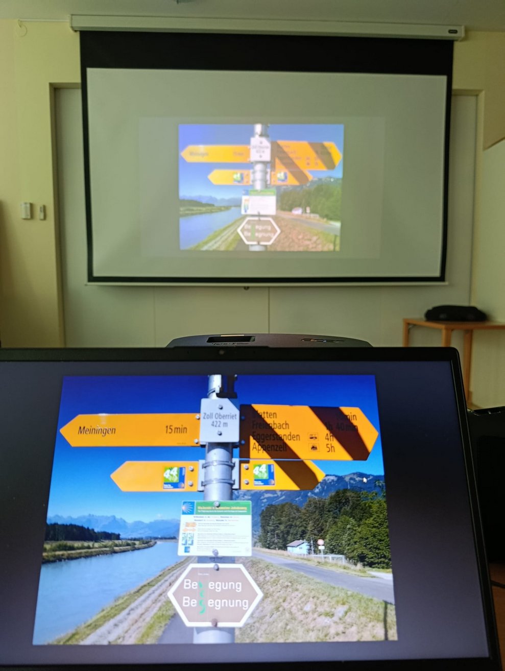 Tafel mit Wegweisern auf Computer und Leinwand.