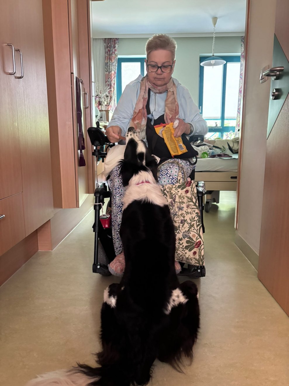 Bewohnerin füttert Hund.