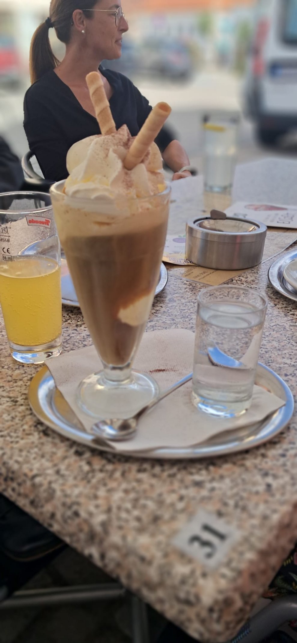 Eiskaffee mit Schlagobers und zwei Waffelröllchen.