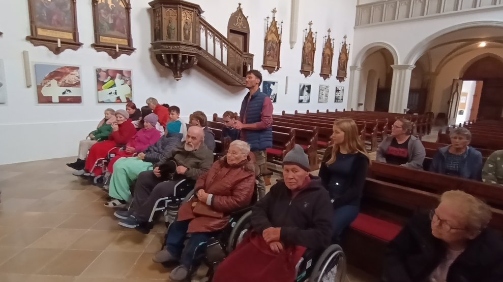 BewohnerInnen, Lehrer, SchülerInnen und ehrenamtlich Tätige beim Beten in der Kirche.