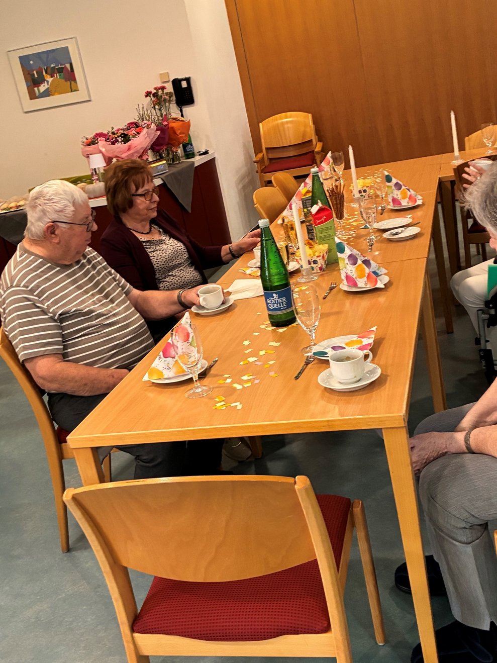 Personen sitzen beim Tisch.