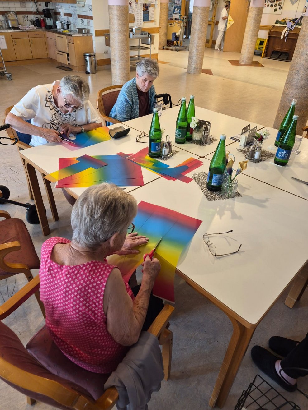 Bewohnerinnen basteln mit Buntpapier.
