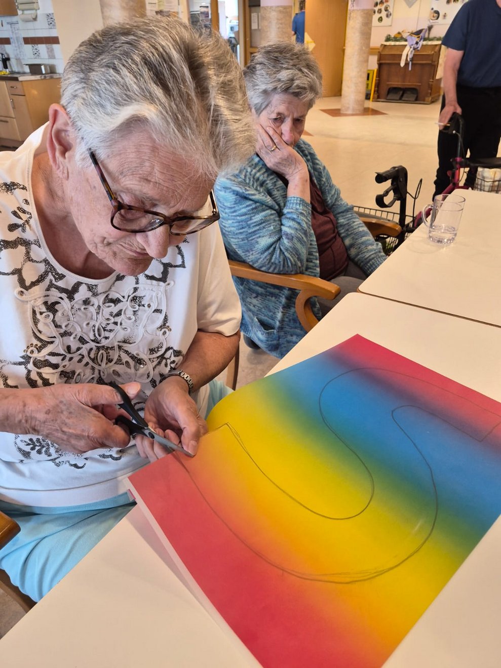Bewohnerin schneidet Buntpapier.