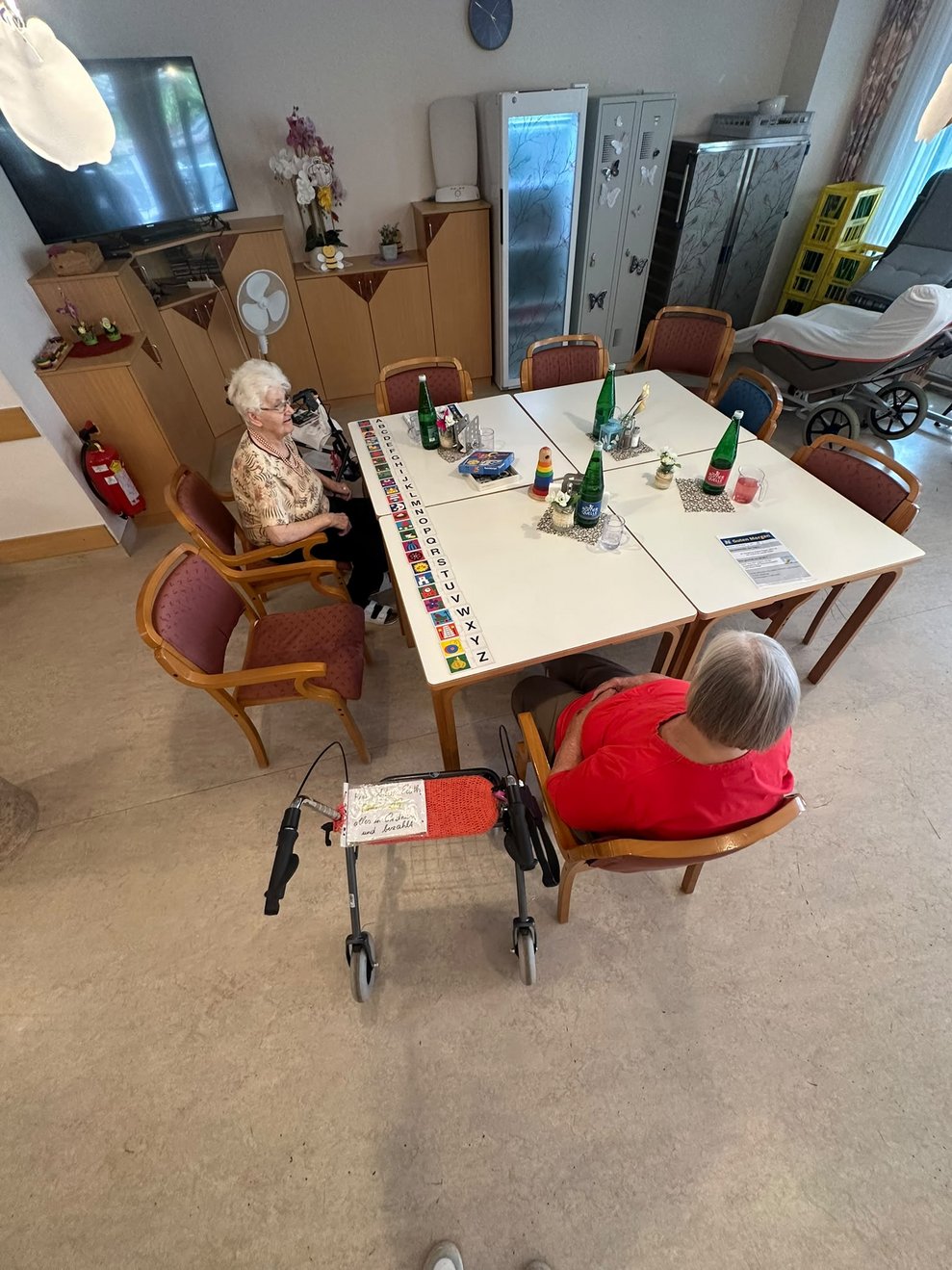 Zwei BewohnerInnen beim Spielen. Spielkärzchen liegen auf Tisch.