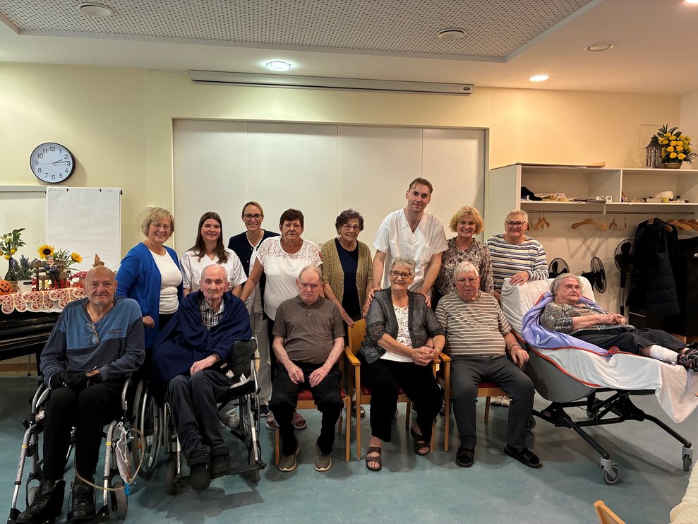 Gruppenfoto mit sitzenden BewohnerInnen und stehenden GratulantInnen.