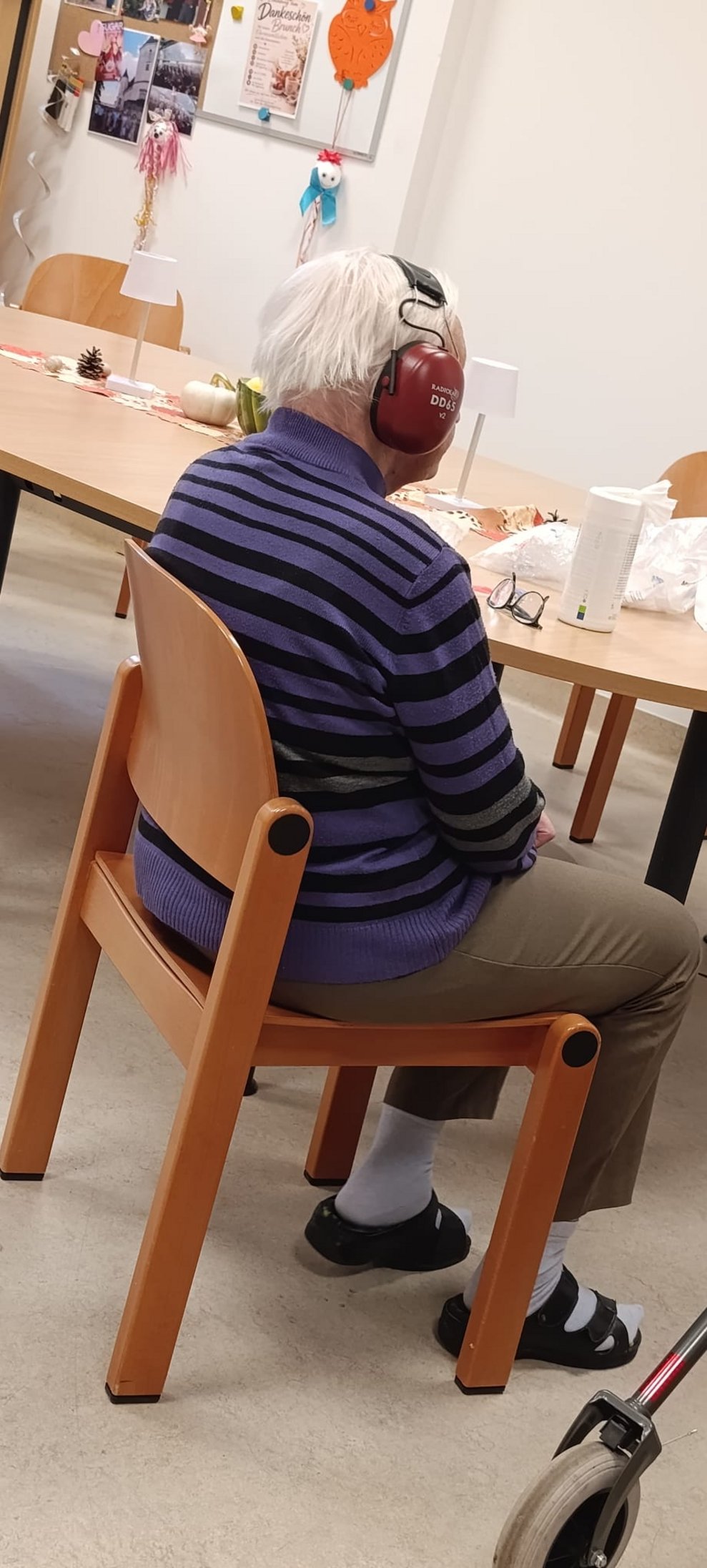 Sitzender Bewohner hat Kopfhörer beim Hörtest auf.