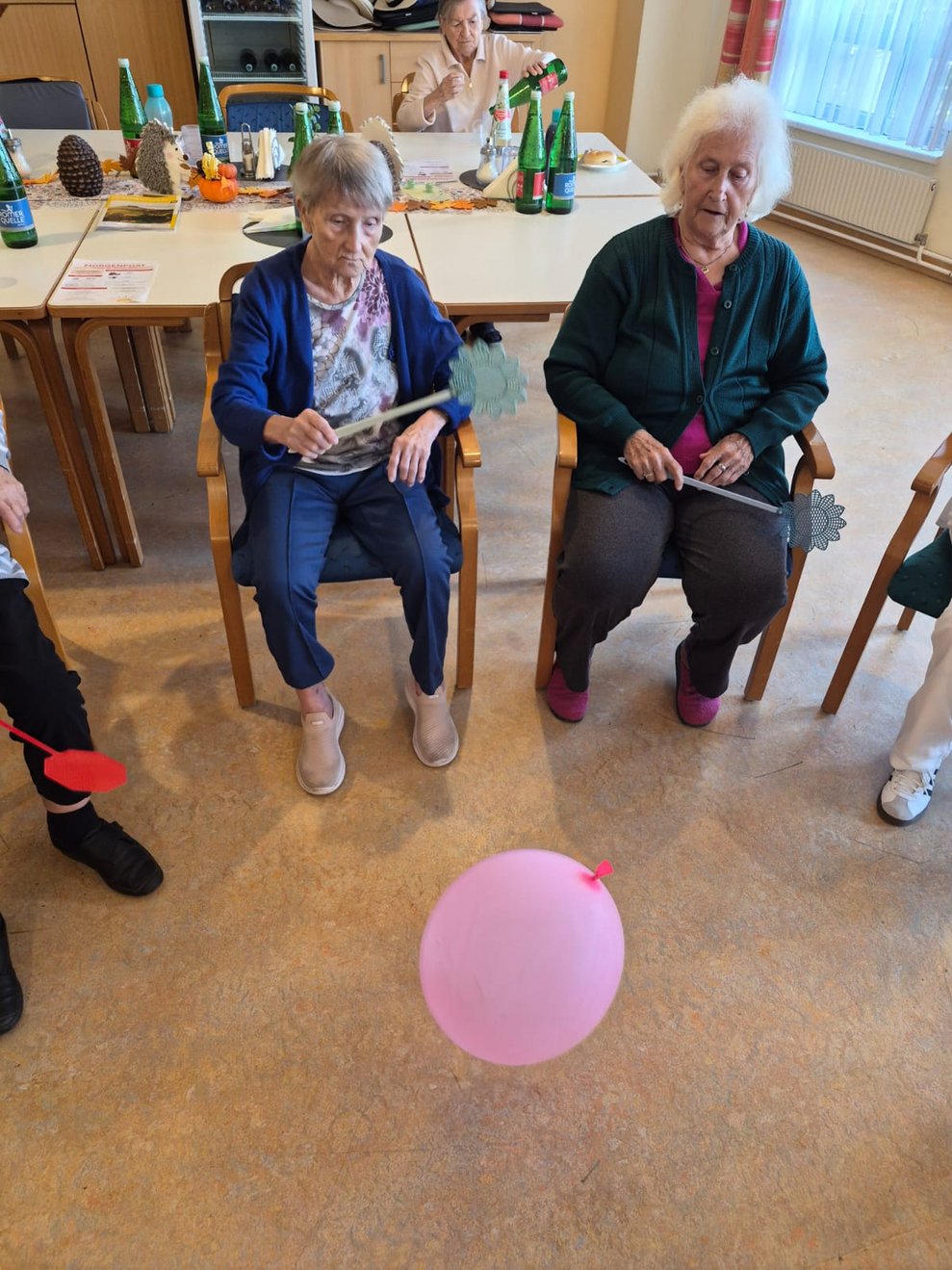 Luftballon liegt auf Boden. Sitzende Bewohnerinnen.