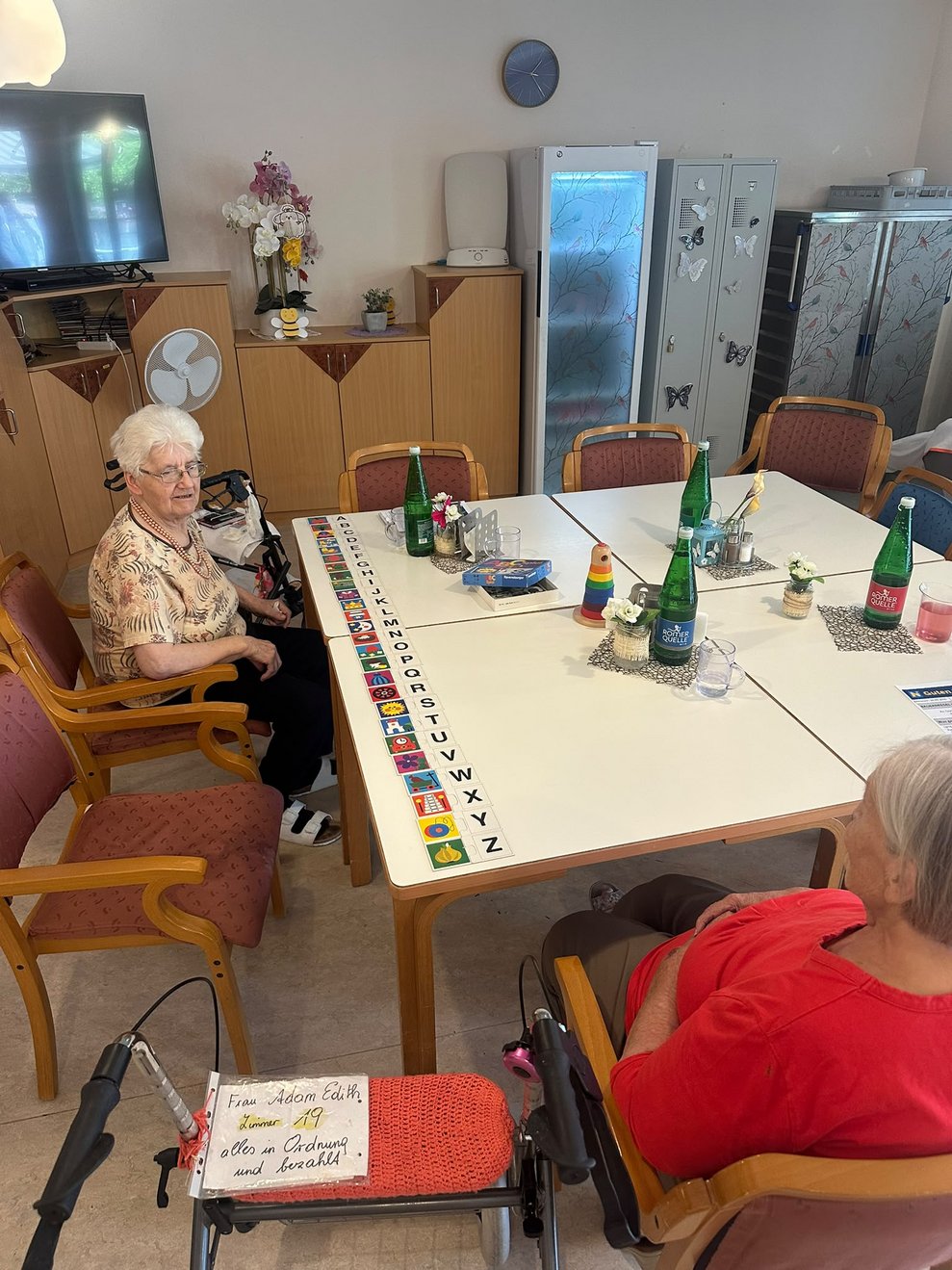 Zwei BewohnerInnen beim Spielen. Spielkärzchen liegen auf Tisch.