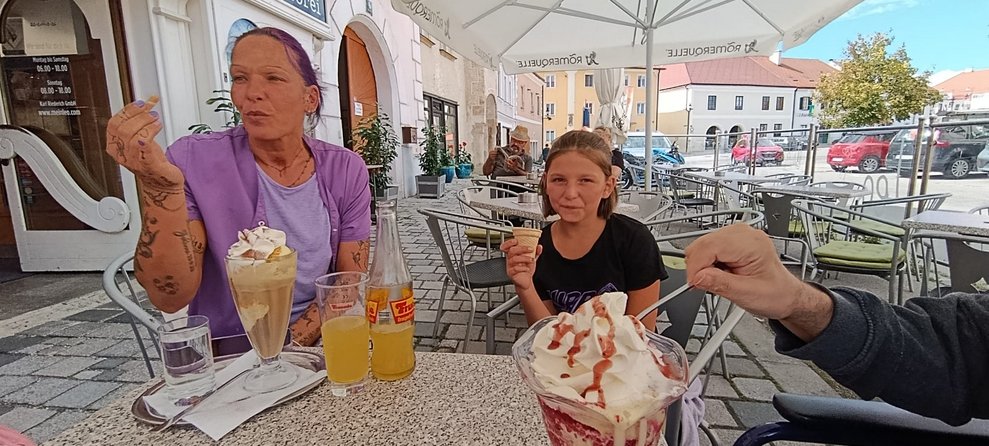 Alltagsbegleiterin mit Eiskaffee. Kind beim Eis schlecken.