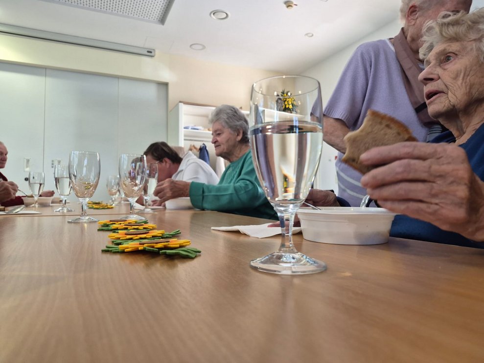 Personen beim Gemüsesuppe und Brot essen.