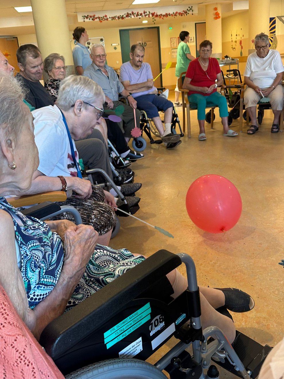BewohnerInnen halten Fliegenpracker in der Hand. Luftballon liegt auf Boden.